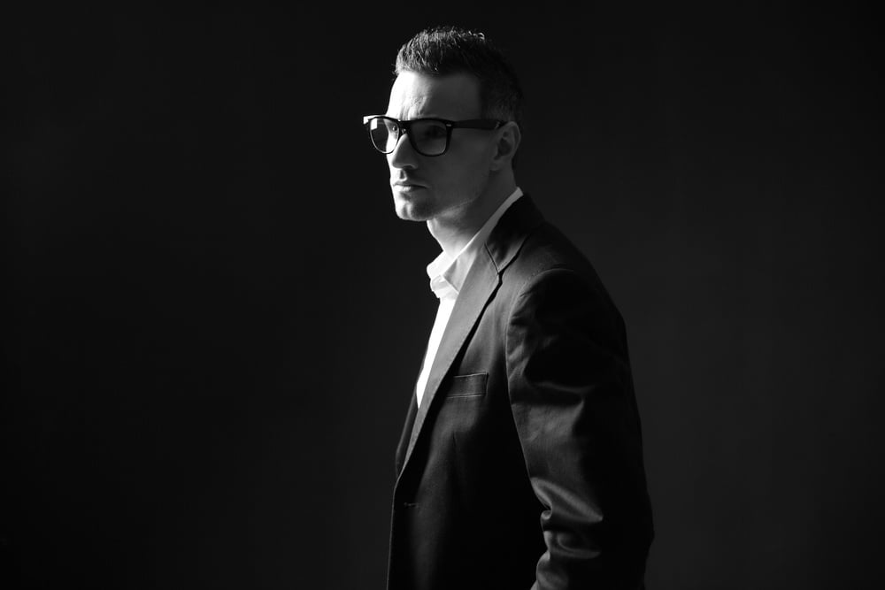 Black and white photo of a thoughtful businessman in glasses